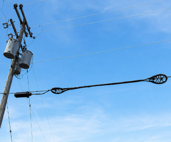 pole-mounted cable slack storage in an aerial telecommunications network